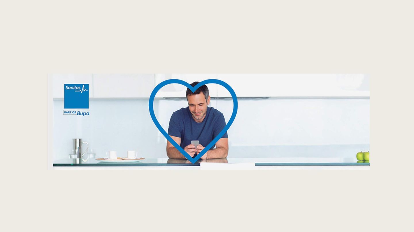Man in a kitchen looking at his mobile