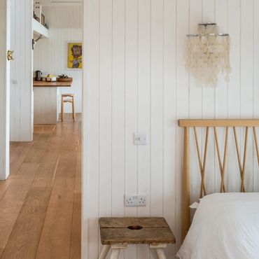 View taken from the master bedroom looking through the open bedroom door towards the open plan living and kitchen area beyond