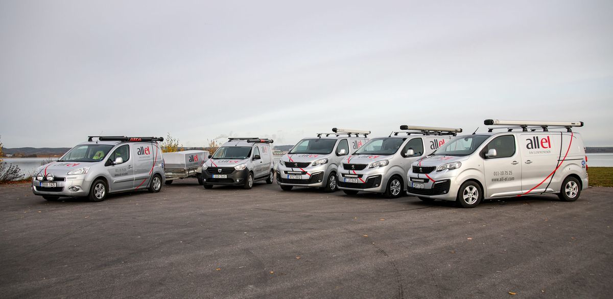 Fyra elektriker i varselkläder står uppställda framför sina bilar. 