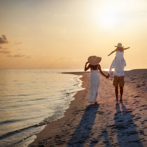 Familij som går på stranden