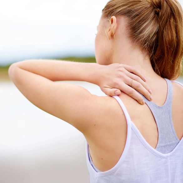 Kvinna som lider av muskelspänningar i nacken