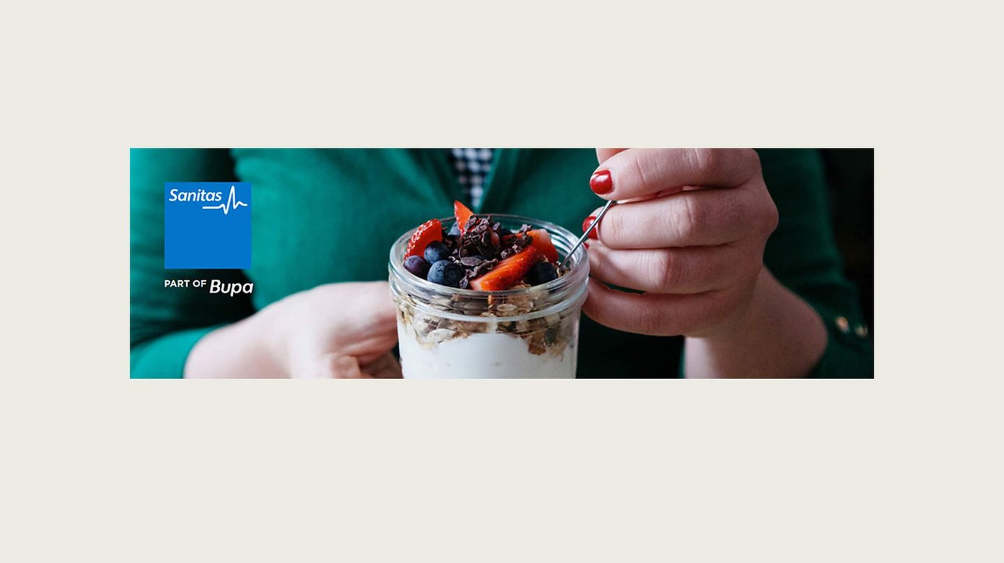 Kvinna äter Granola ur en glasburk