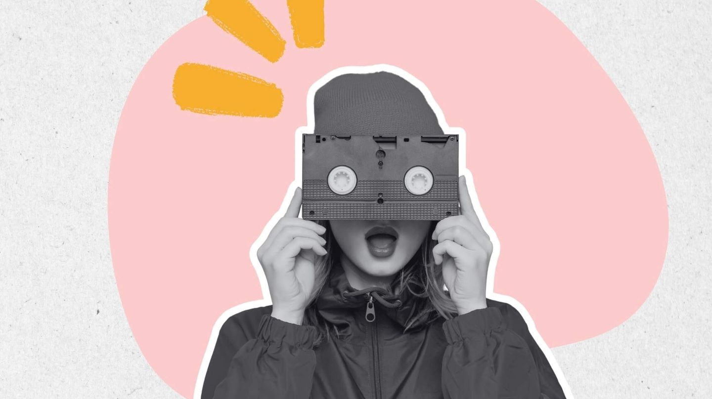 Kvinna som håller en gammal VHS-kasett framför ansiktet.
