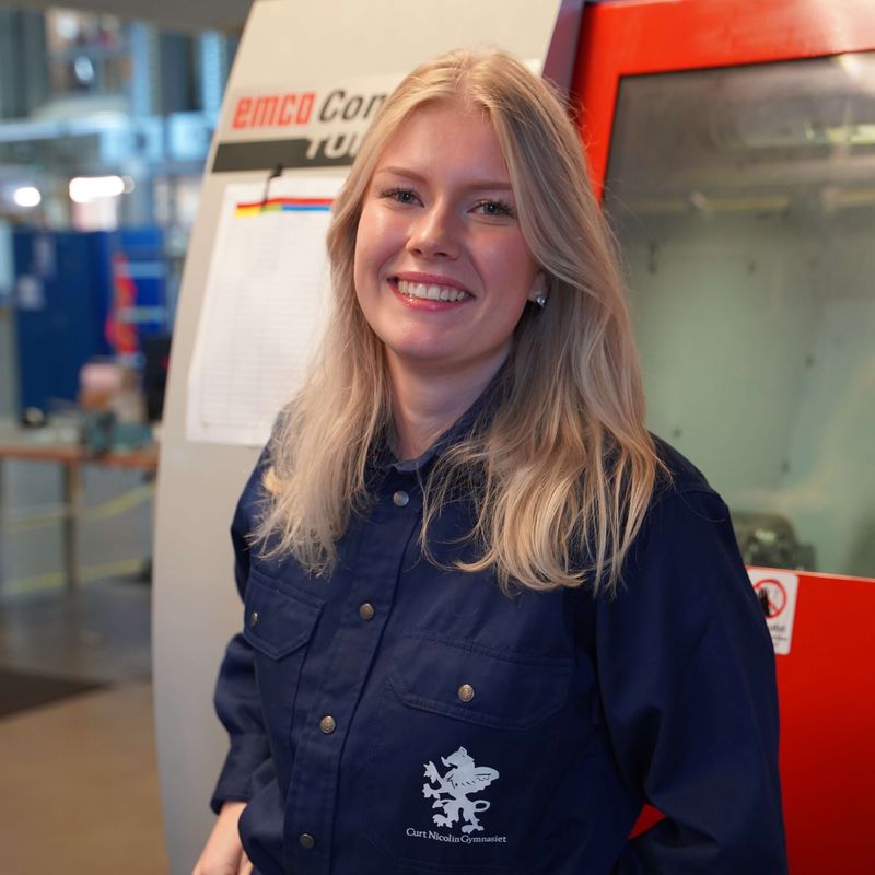 Felicia ler mot kameran i verkstaden på CNG