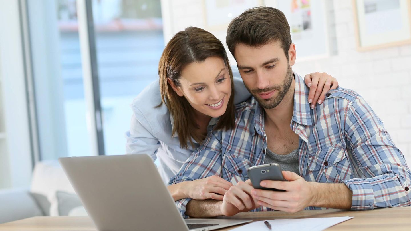 Copule in front of computer and mobil phone