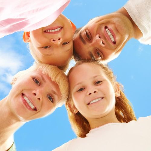 Family outdoors with their heads together