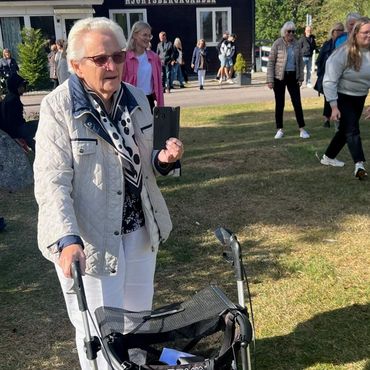 Bild på en seniorkvinna i en samling ute