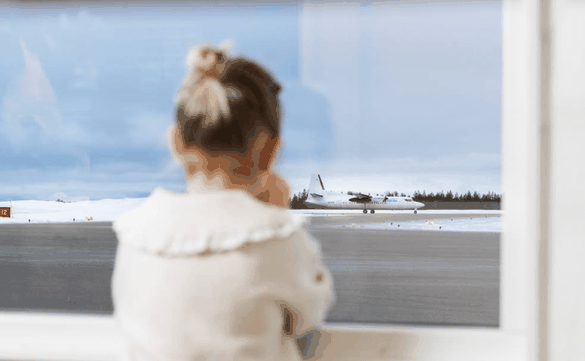 Barn tittar på flygplan från fönster