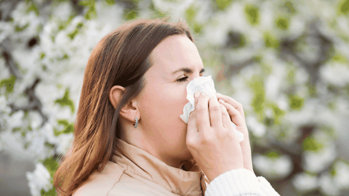 A woman blowing her nose