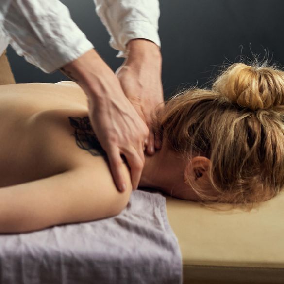 Massageterapeut masserar nacke för att lindra spänningshuvudvärk