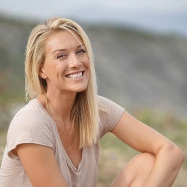 Woman sitting on nature smiling