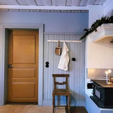Locktak i massivt trä i traditionellt kök med blå innerpanel och gammal träspis