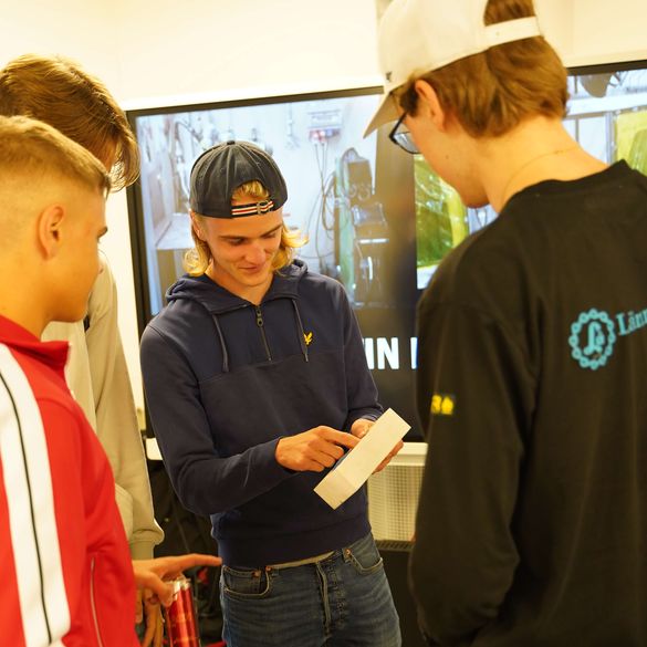 Elever tittar på material från Lämneå bruk tillsammans med en av deras anställda