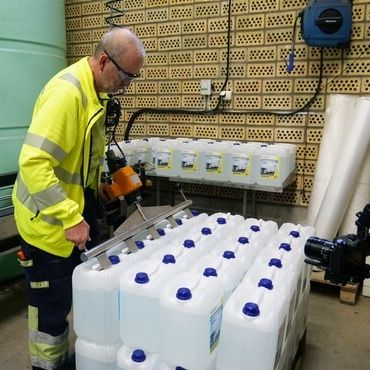 Medarbetare fyller på dunkar med AdBlue