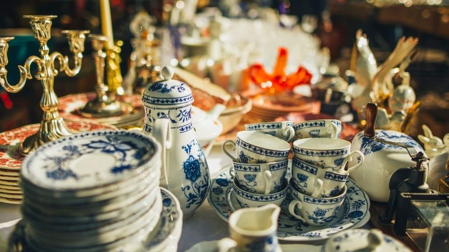 Porslin, ljusstakar och andra fynd uppdukade på ett loppisbord