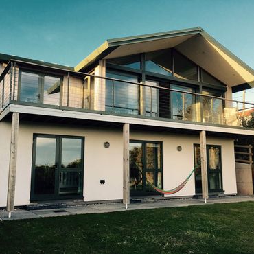 View of the house from the garden showing three of the garden bedrooms and full width balcony