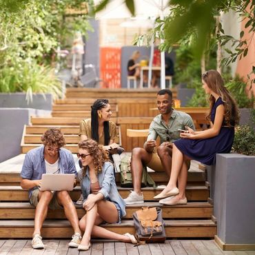 Eine Gruppe von Studierenden sitzt auf der Treppe