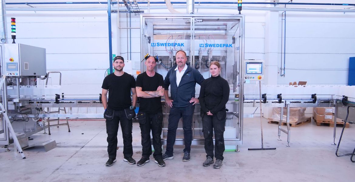 Personalen på Kemiverken i Skänninge står framför fabrikens nya fyllningsmaskin