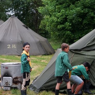 Bild på tre Uv-scouter som går in i ett militärtält