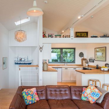 The open plan living room with view to stairs and kitchen