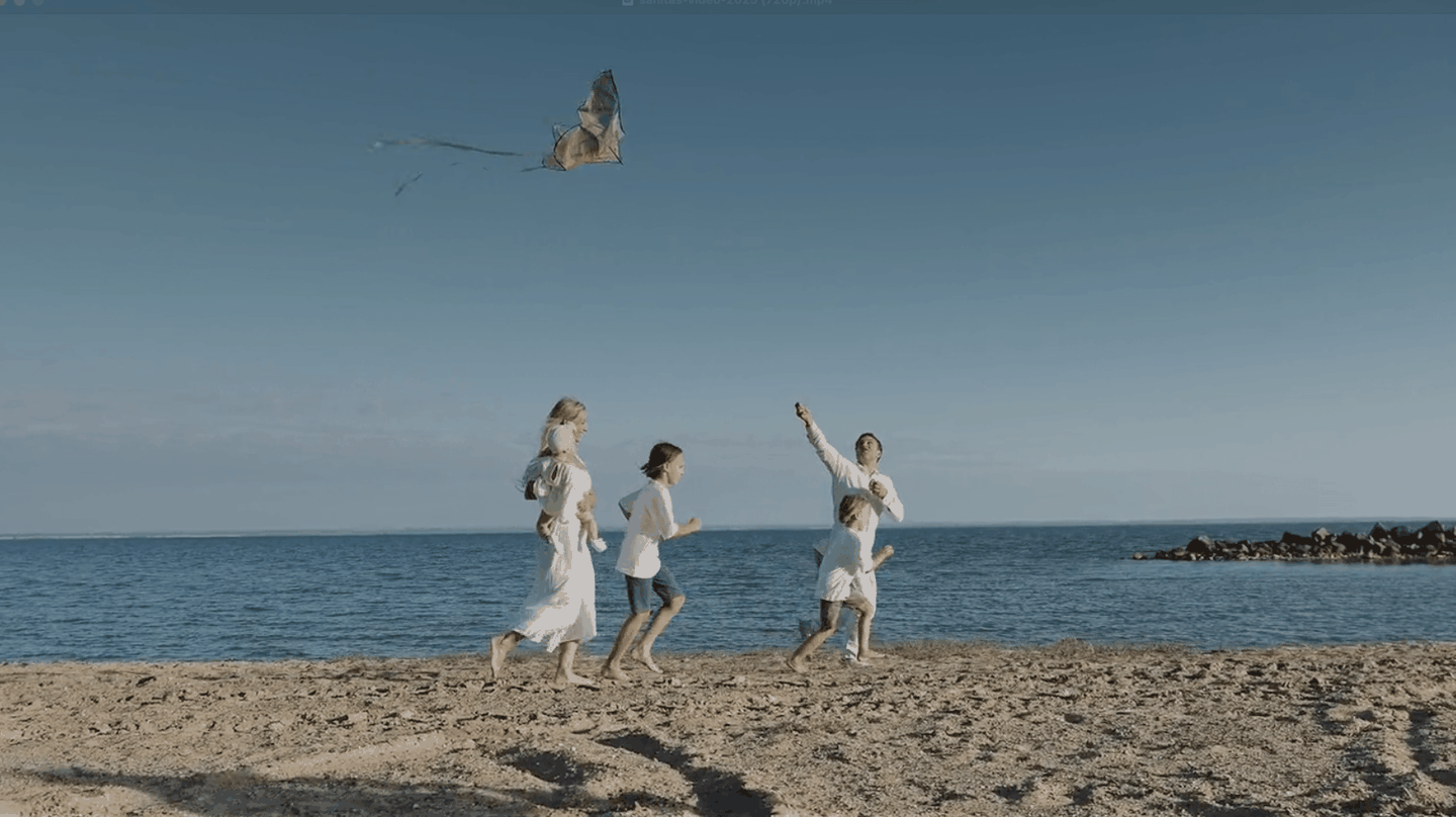 Family with a kite running on the beach